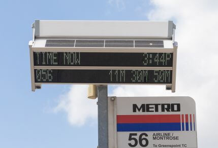 Digital sign affixed to top of bus stop information pole showing real-time arrival information for next bus along 56 Airline / Montrose route.