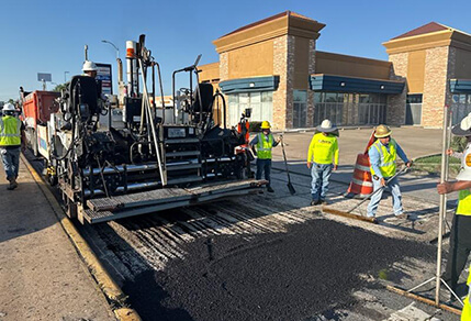 Construction crew pouring asphalt along Hillcroft Avenue.