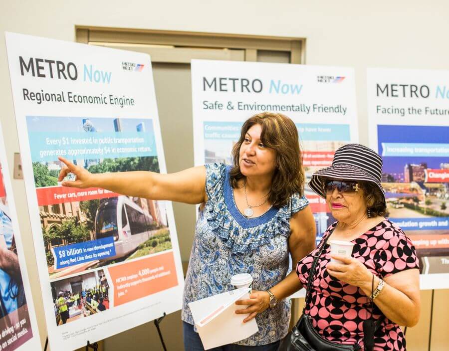 Community members looking at METRONext information boards.