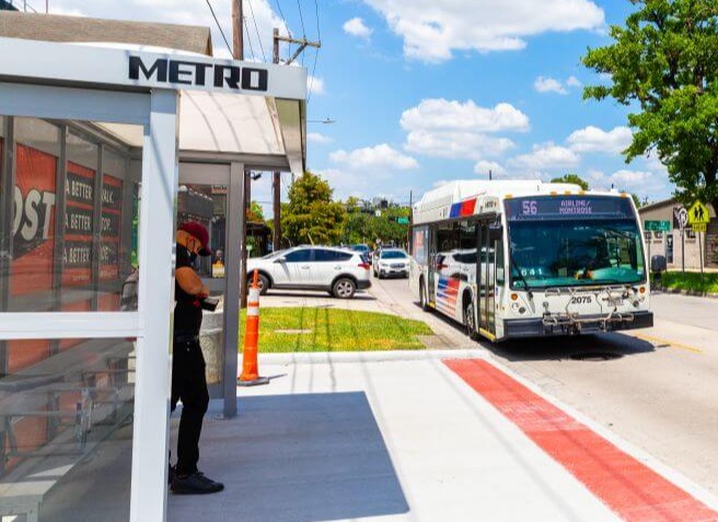 4928-METRONext-BOOST-56 Customer waiting in newly designed bus shelter as 56 Airline / Montrose bus approaches