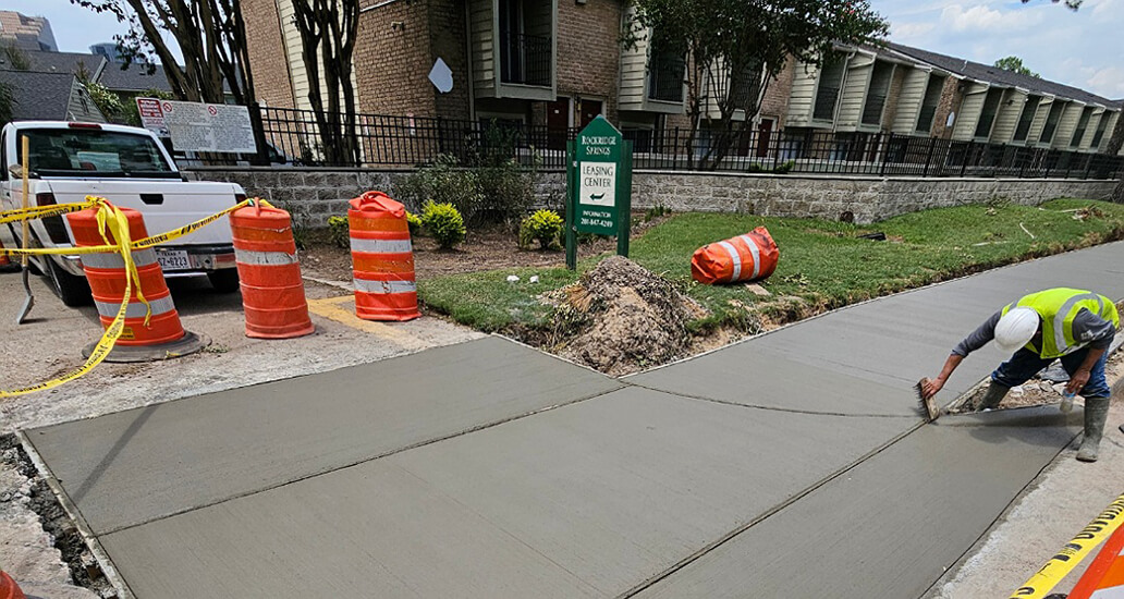 Repairing sidewalk and driveway in front of apartments on Imperial Valley