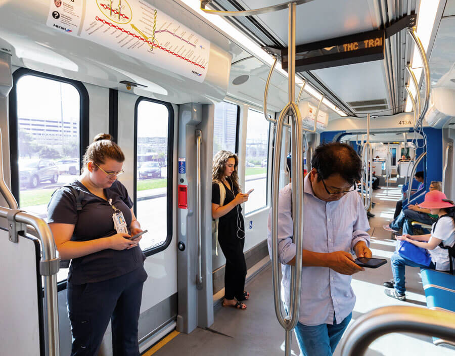 METRORail riders on mobile phones.