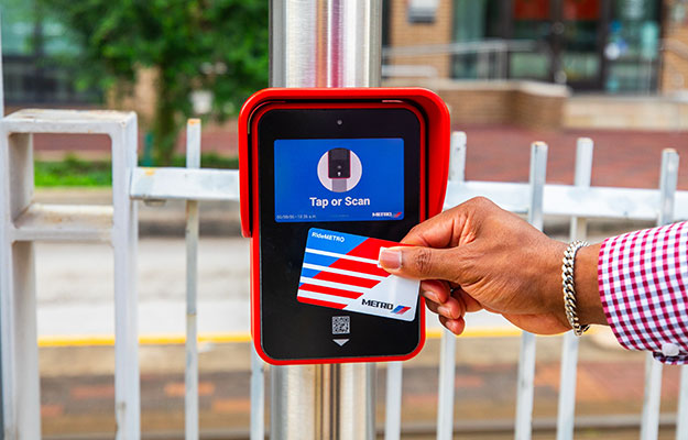 Customer tapping RideMETRO Fare Card on fare validator