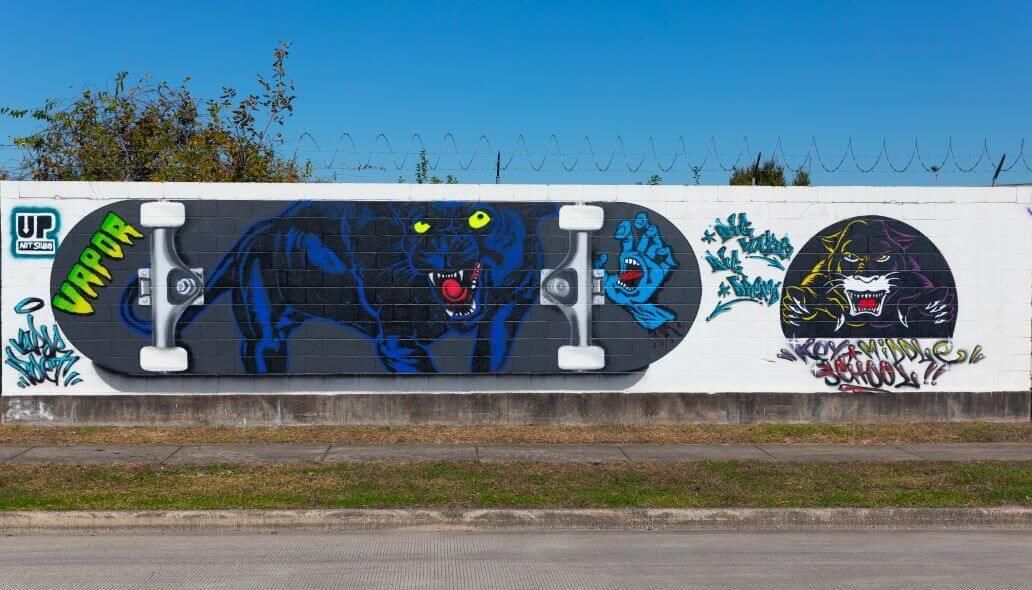 Mural of a panther against the underside of a skateboard along the outer wall of the Kashmere bus operating facility at 5700 Eastex Freeway in Houston