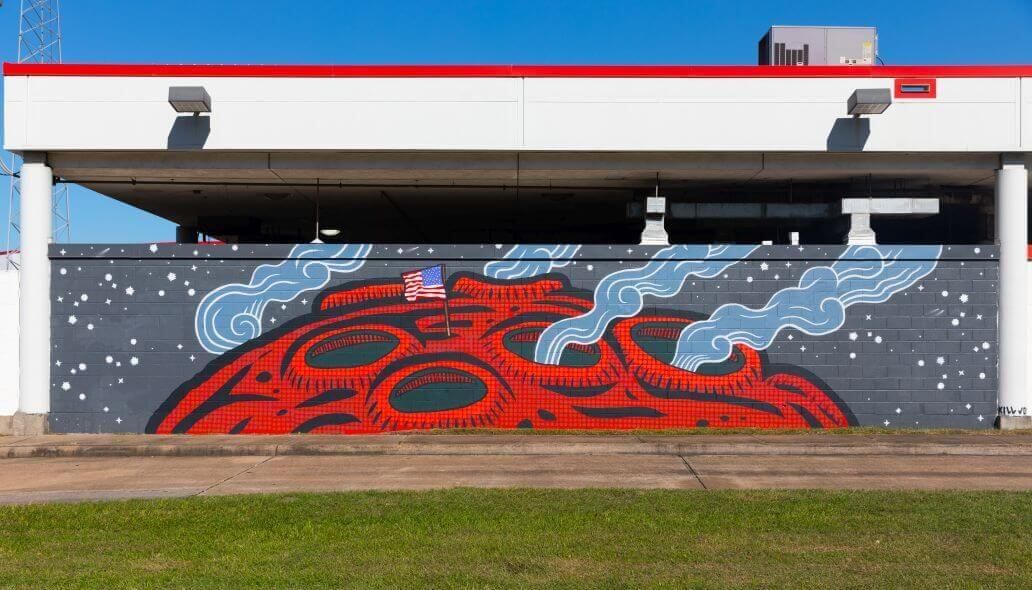 Mural of a planetary service with the American flag planted in along the outer wall of the Kashmere bus operating facility at 5700 Eastex Freeway in Houston