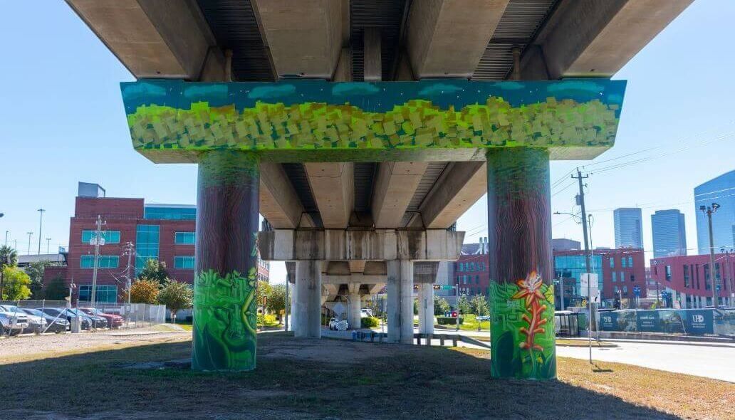 Mural of flowers and trees under the elevated train tracks near the intersection of North Main Street and Naylor Street