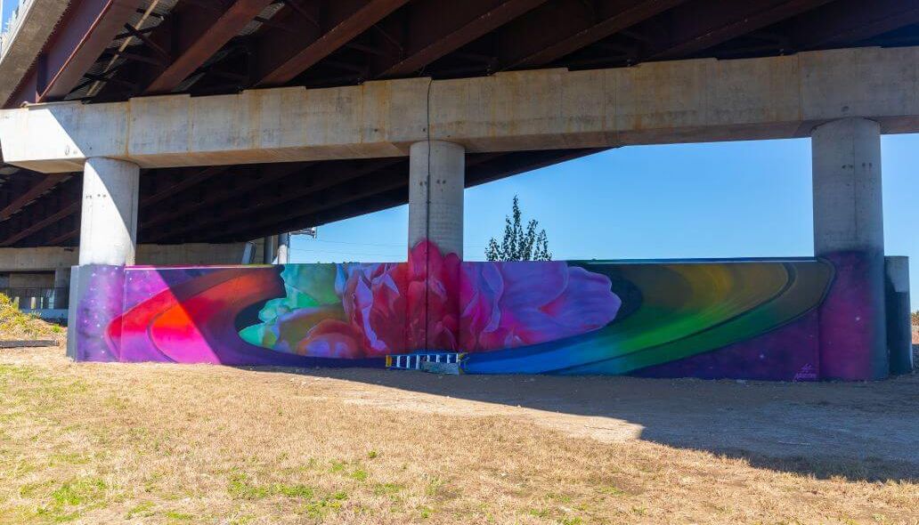 Colorful mural featuring planetary rings along the retaining wall across from Main Street at the Burnett Transit Center.