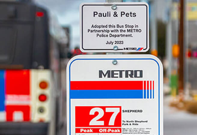 Signage on a bus stop pole showing the spot has been adopted.