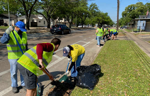 Rider seated in a bus shelter looking down at their phone while waiting for a METRO bus along the 9 Gulfton / Holman route.