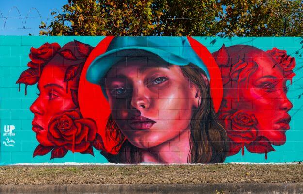 Mural of three women along the outer wall of the Kashmere bus operating facility at 5700 Eastex Freeway in Houston