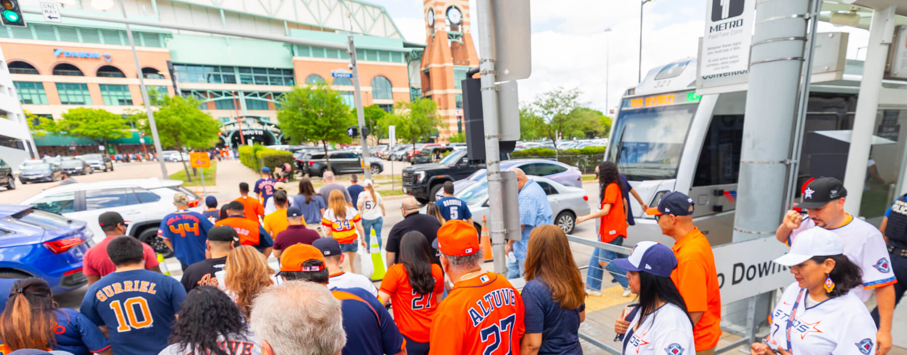Crowd of Astros fans leaving METRORail train and heading toward Daikin Park.