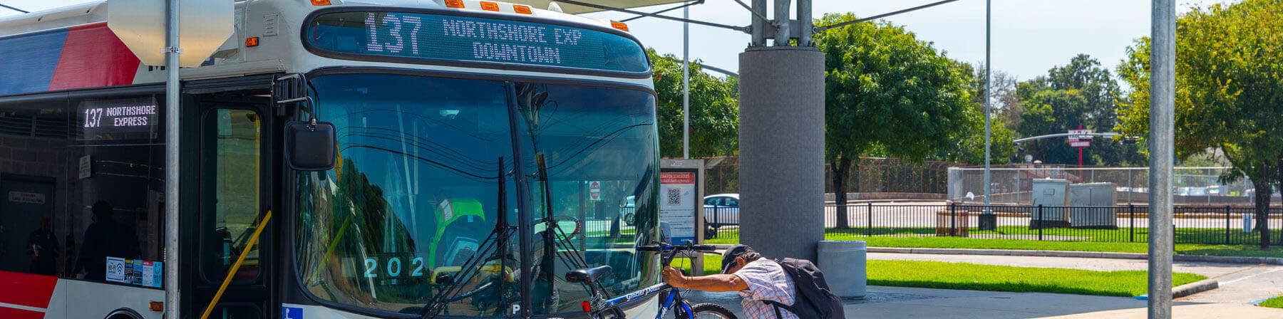 137 Northshore Express bus and bike rider placing bike on bike rack.