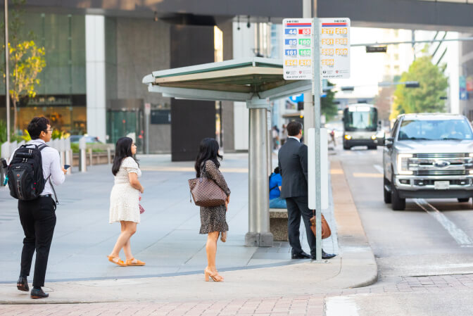 Riders waiting for bus to arrive in Downtown stop