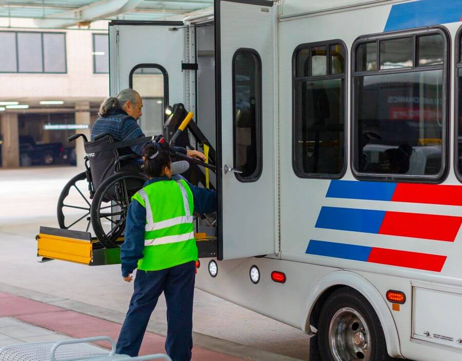 METROLift rider in a wheelchair on electric lift boarding a METROLift vehicle