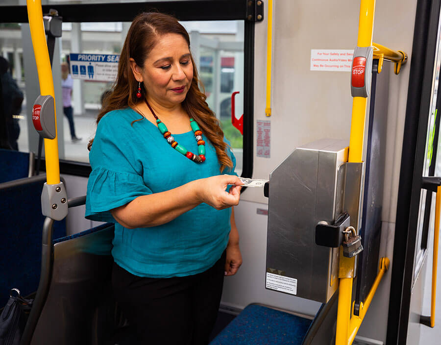 Passenger submitting dollars into ticket machine