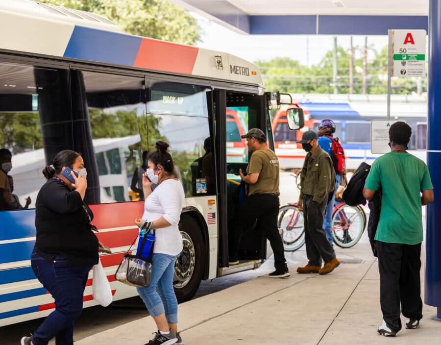 Riders boarding a local bus at a METRO transit center.