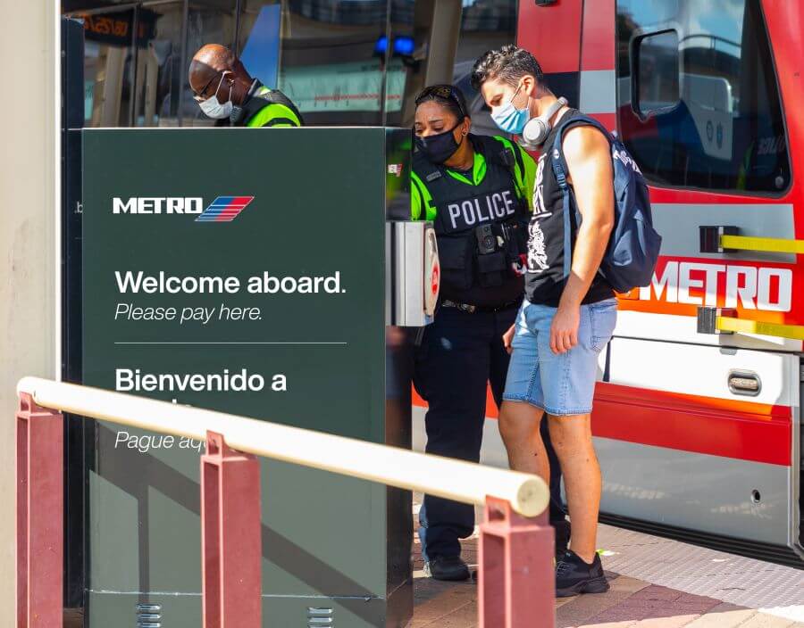 METRO police officer assisting customer at ticket vending machine along METRORail platform