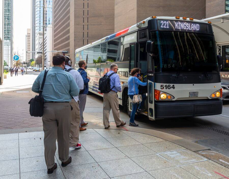 Businesspeople boarding METRO Park & Ride bus in downtown Houston.