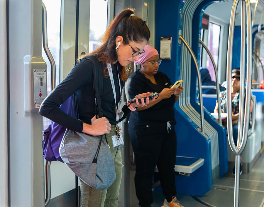 METRORail passengers on their phones wearing headphones