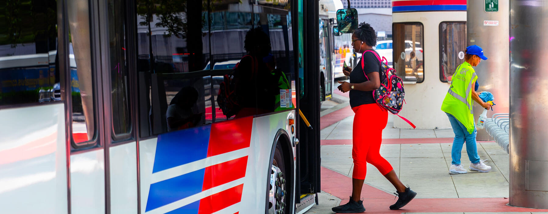 Woman stepping onboard a local bus at a transit center.