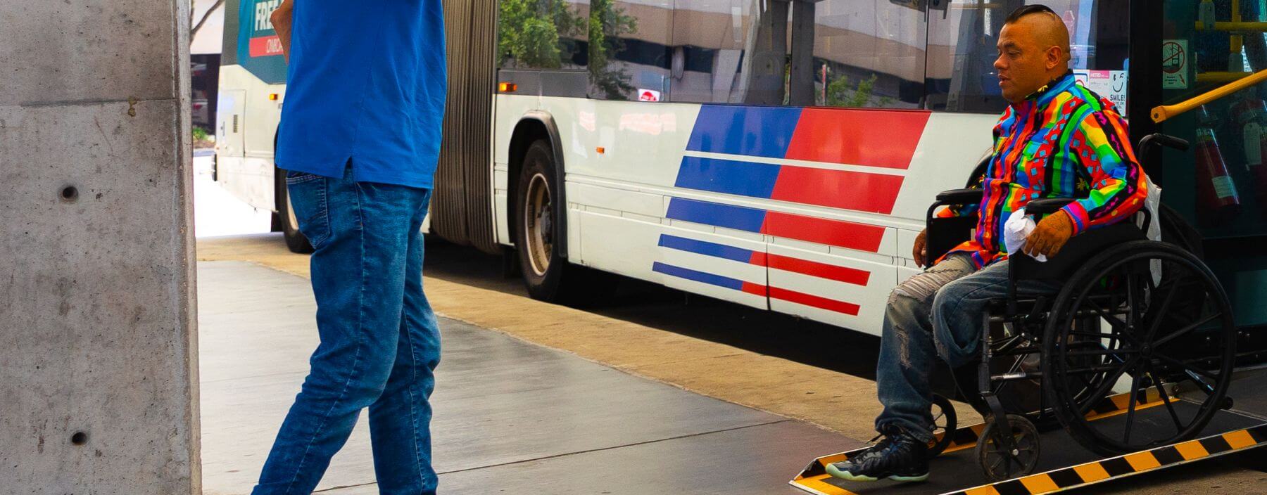 Rider in wheelchair exits METRO local bus on a ramp