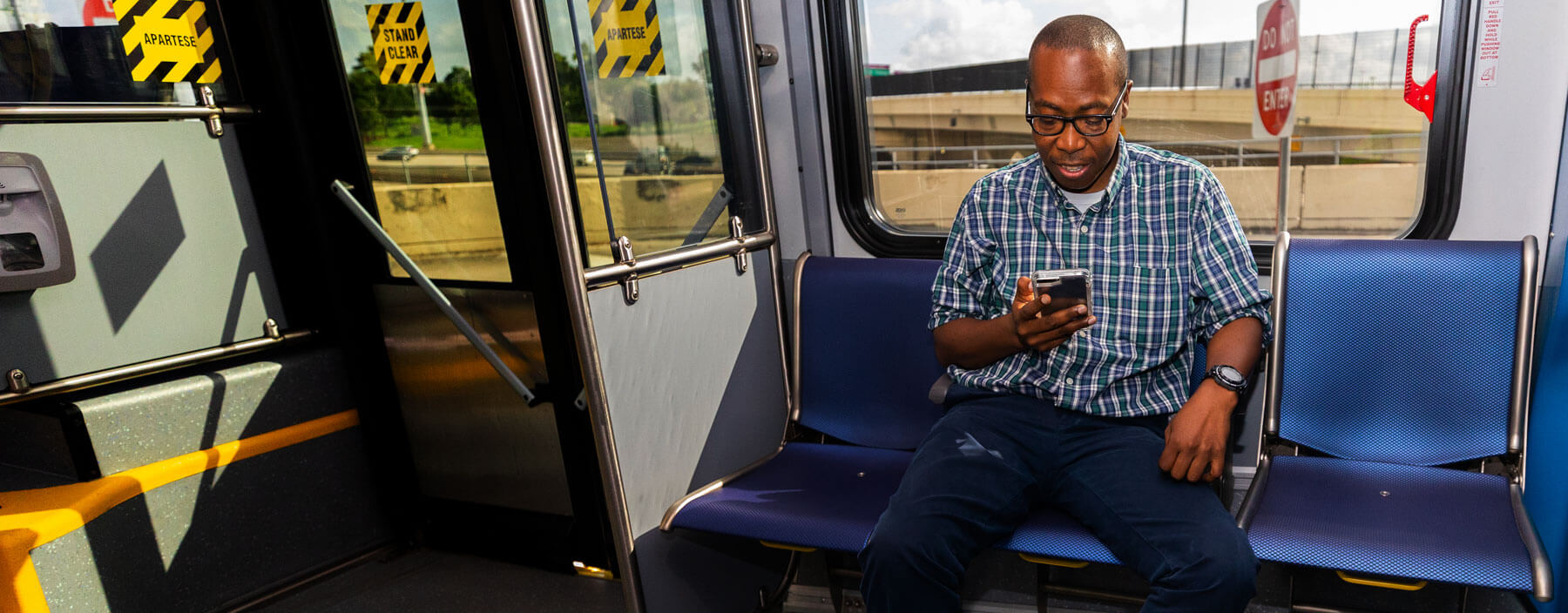 Customer looking at his phone while riding on the METROrail.