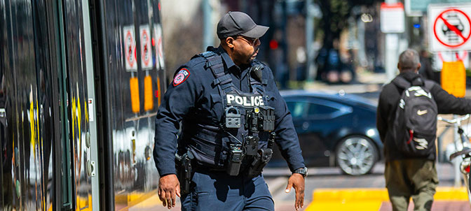 METRO uniformed police officer patrols light rail train to ensure rider safety.