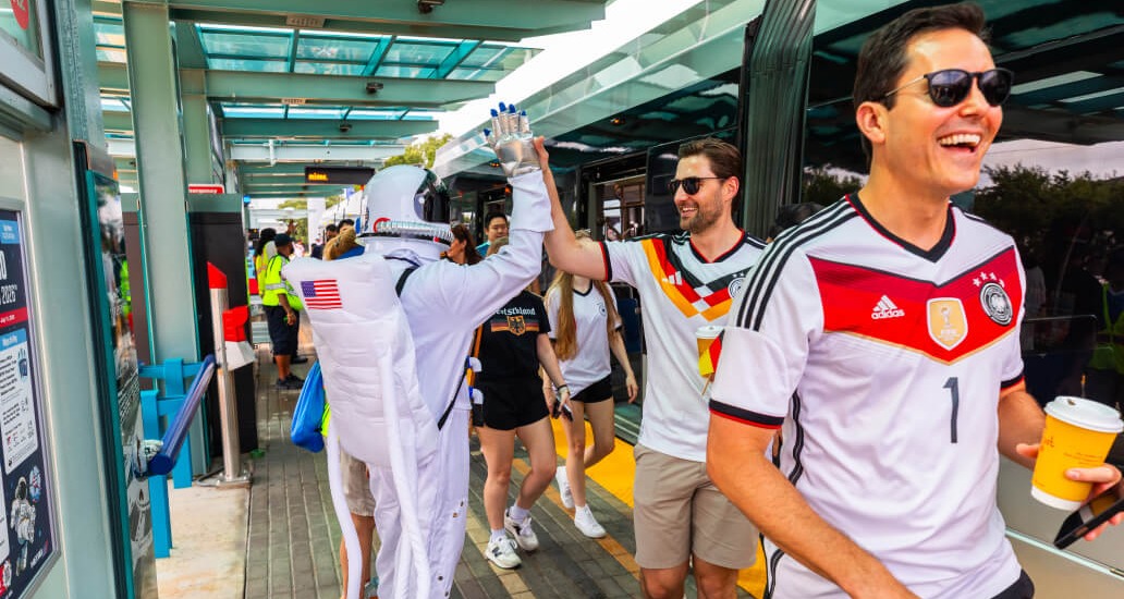 METRO Astronaut mascot high-fives a METRO rider wearing a Germany soccer jersey.