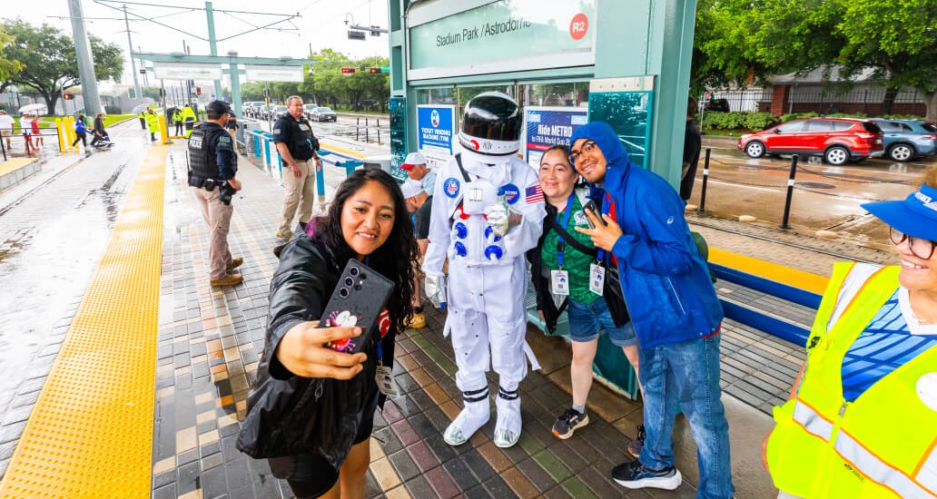 A woman taking a selfie with the METRO Astronaut mascot.