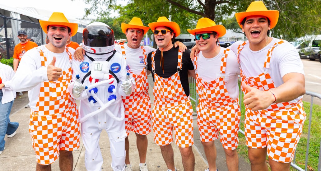 Group of Netherlands fans pose with the METRO Astronaut mascot.
