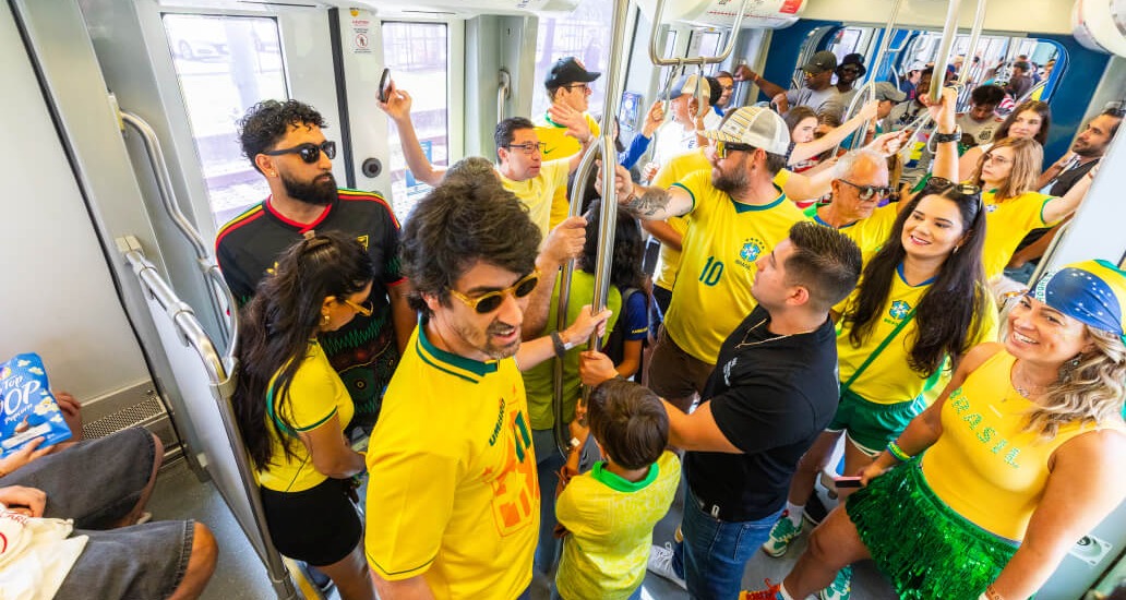 Train filled with Brazil soccer fans wearing green and yellow jerseys during the World Cup.