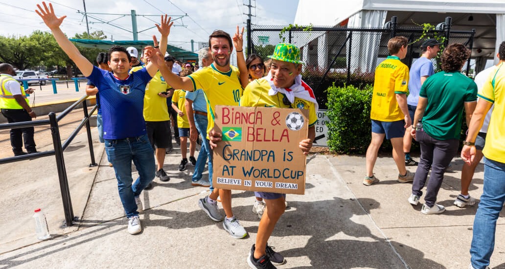 Rider walking while holding up sign saying “Bianca & Bella, Grandpa is at World Cup. Believe in your dream”.