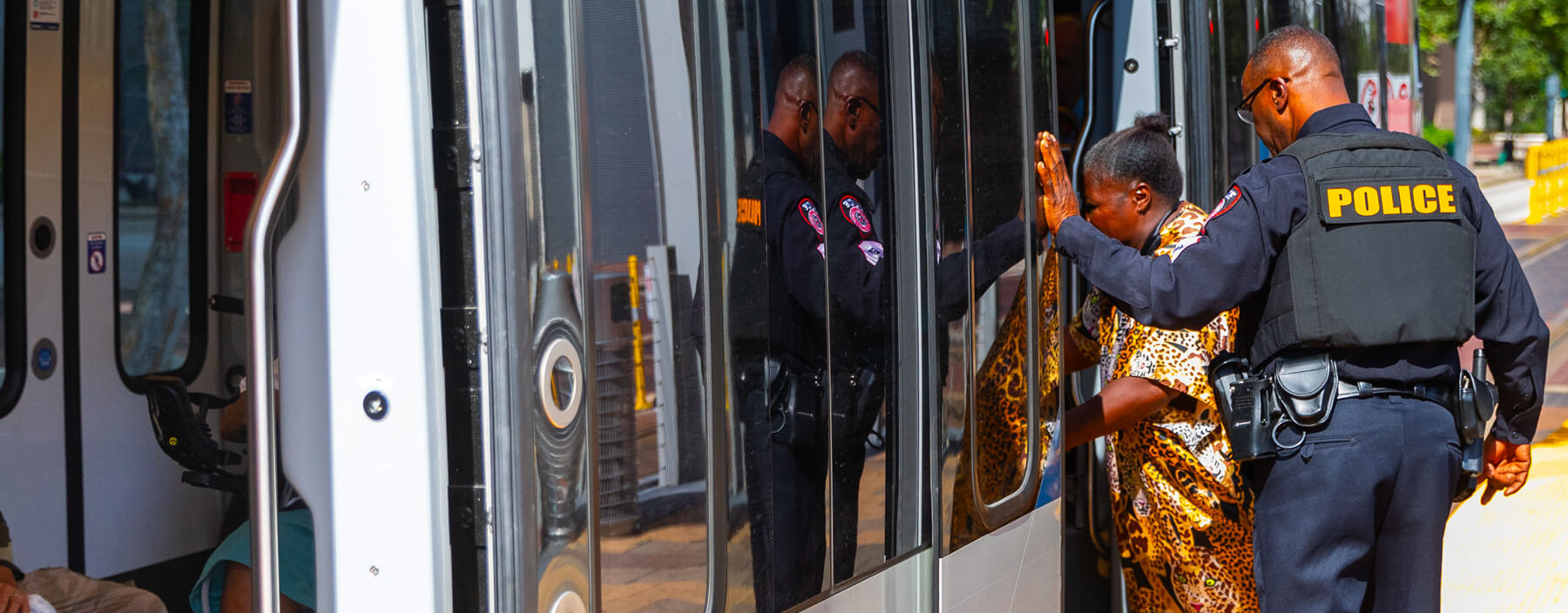 METRO Police Officer assisting rider with walker boarding METRORail train.