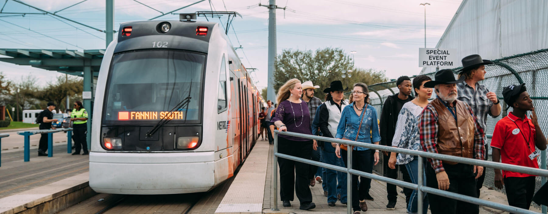 METRORail riders walking toward Rodeo event.