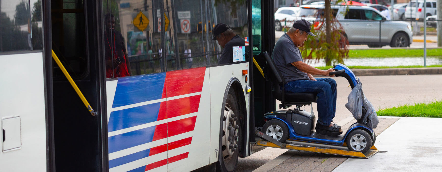 Rider in power scooter getting off a local bus.