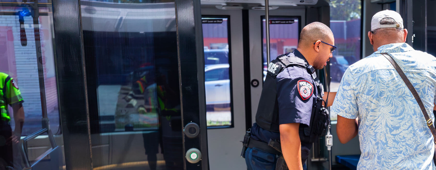 METRO Police officer helping customer with the Ticket Vending Machine at a METRORail platform.