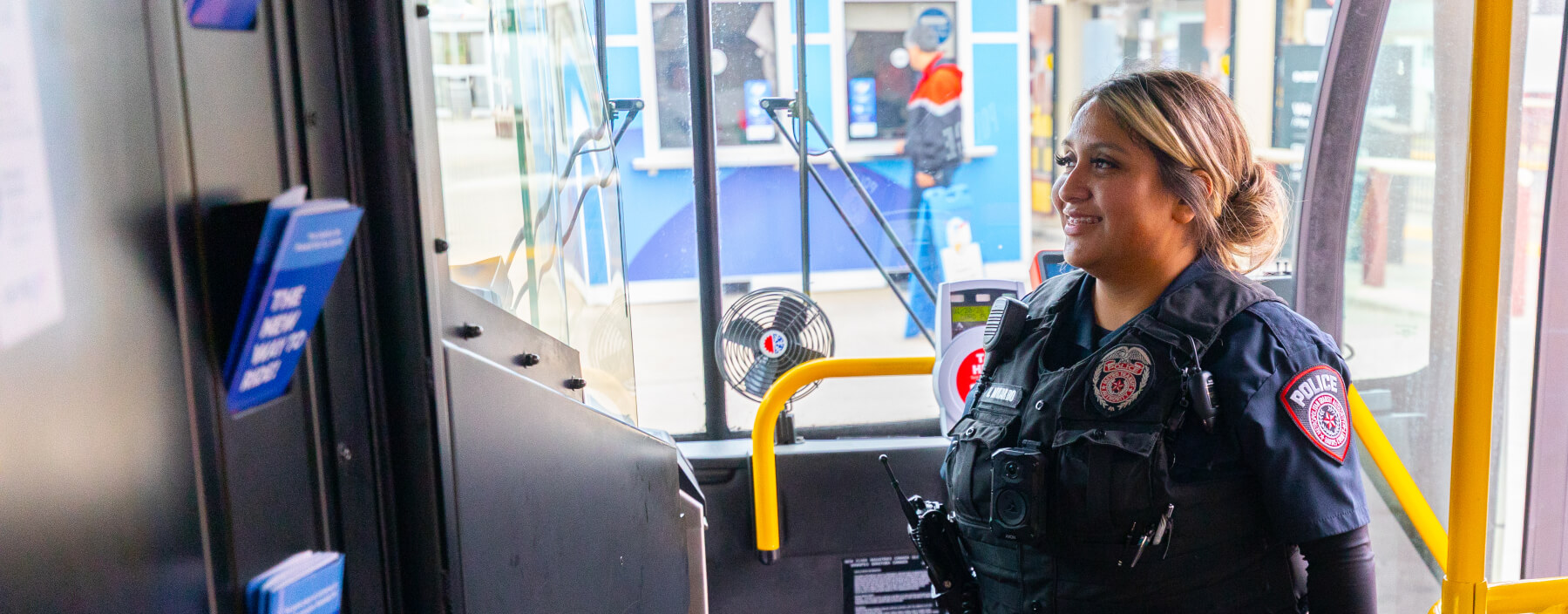 Female METRO Police Officer smiling at bus operator after boarding local bus.