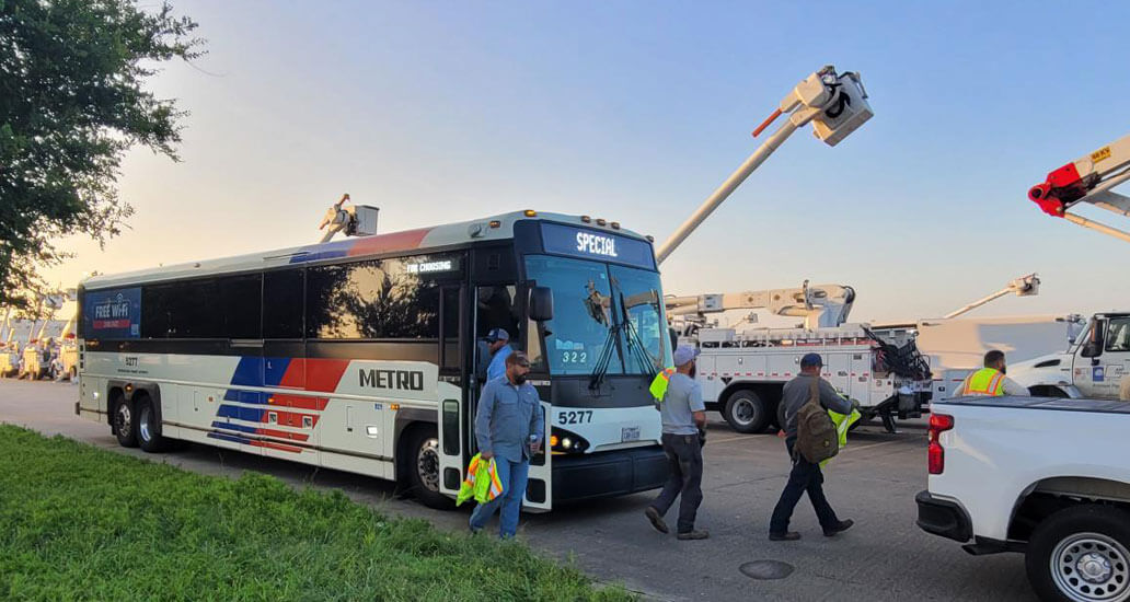 Crews getting of bus to get to utility trucks.