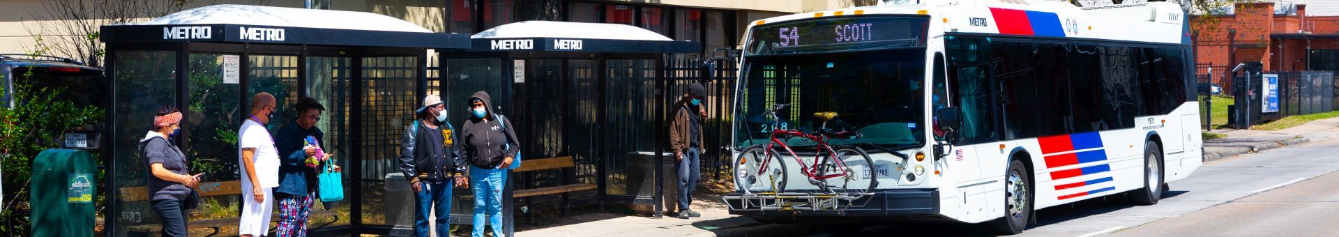 Customers waiting at METRO bus shelters as 54 Scott bus arrives