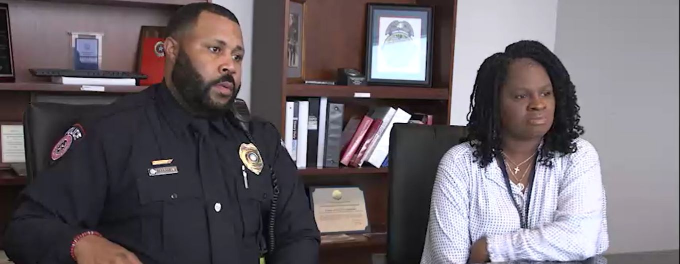 Photo of METRO Police Officer Franklin and Mental Health Clinician Moriah Ojo sitting at a conference table.