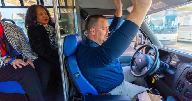 Shuttle operator takes hands off vehicle steering wheel to demonstrate AV technology.