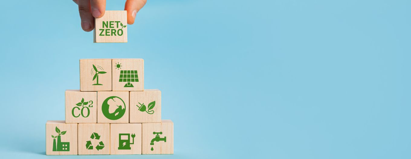 Wood blocks forming a pyramid with green/net zero symbols.