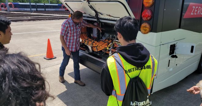 Students take a look under the hood of METRO's first electric bus.