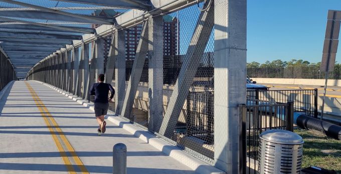 A man runs along the new Post Oak Road Pedestrian Bridge.