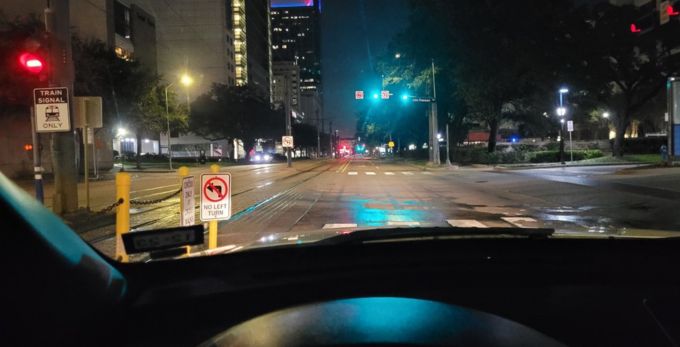 View of a safety sign at night from inside a car.