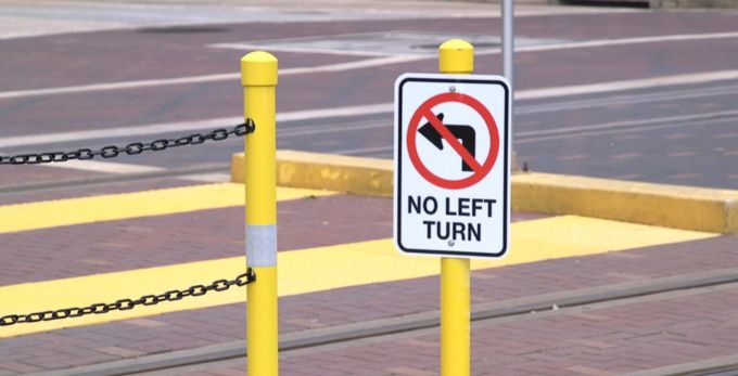 Up close photo of new no left turn sign along rail line.