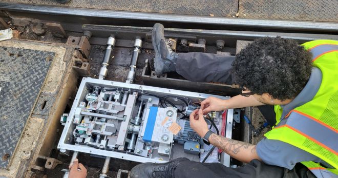 METRO worker making repairs to rail electrical box.