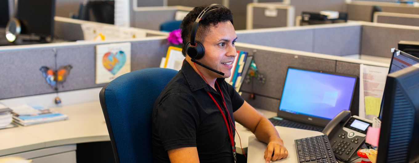 METRO customer service agent with headset at desk.