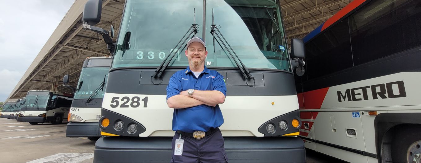 METRO Bus Operator Gary Williams standing in from of a bus.