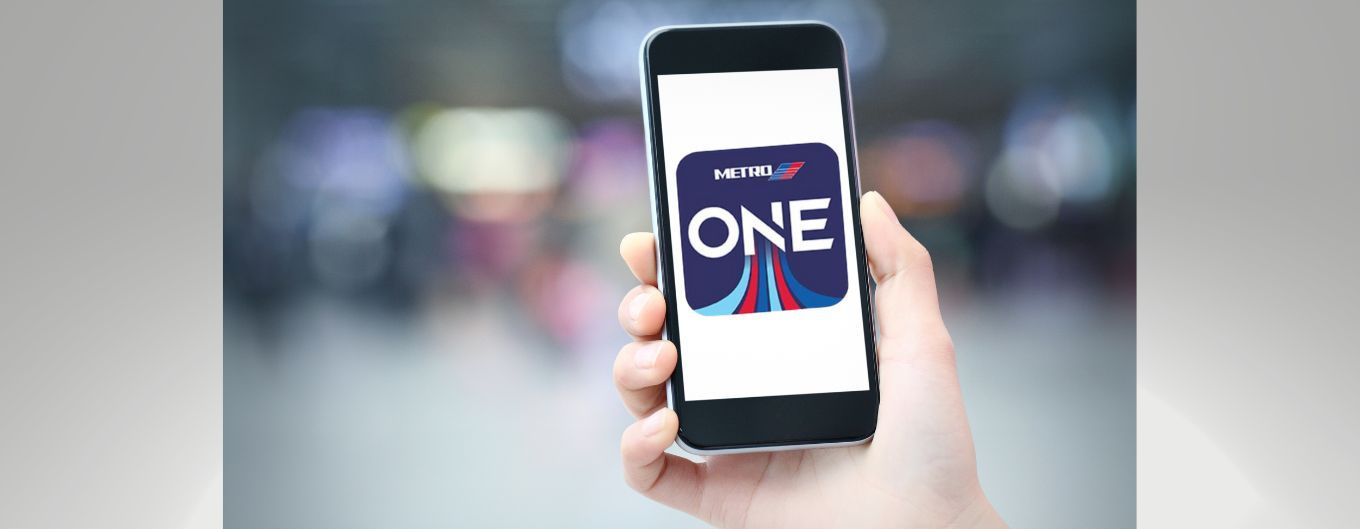 A hand holding a cell phone with the One to Ride app on the screen.